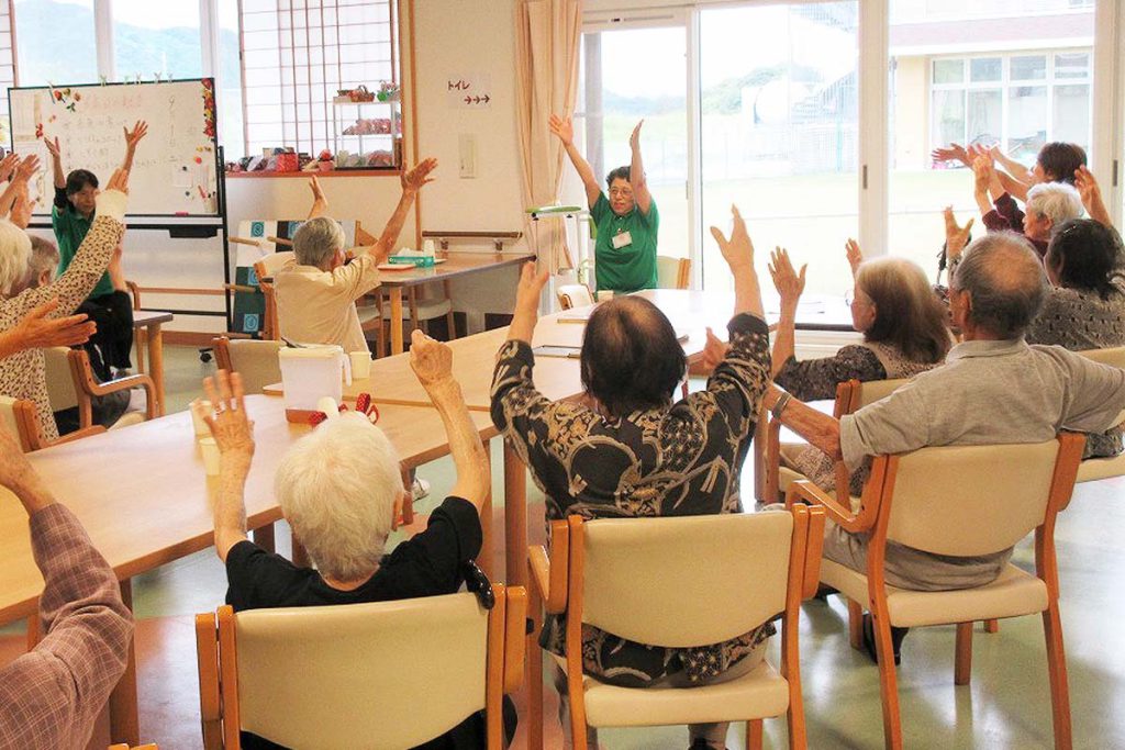 デイサービスで椅子に座って体操する利用者の様子